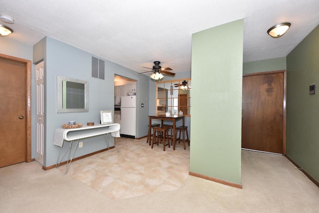 living room with baseboards, visible vents, and light colored carpet