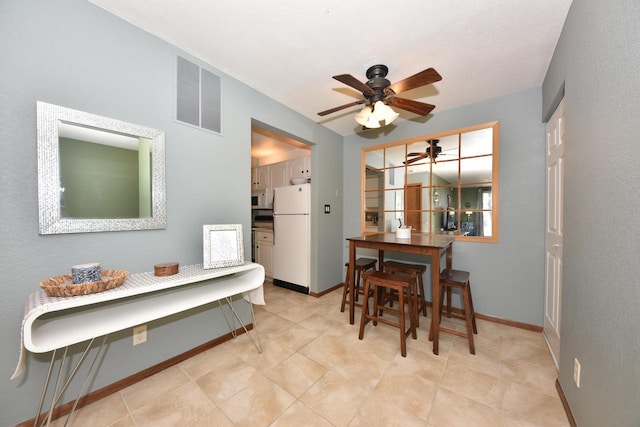 dining area featuring baseboards, visible vents, ceiling fan, and light tile patterned flooring