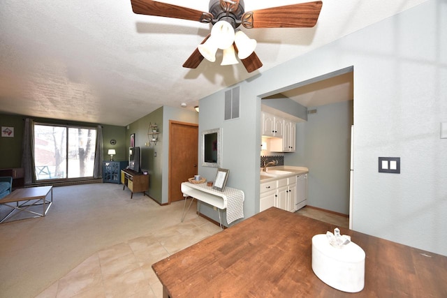 interior space featuring light colored carpet, visible vents, a textured ceiling, and light tile patterned flooring