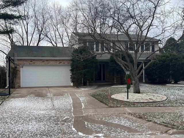 traditional-style home featuring brick siding, an attached garage, driveway, and a shingled roof