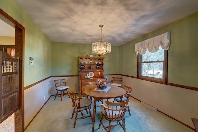 dining area featuring an inviting chandelier, baseboards, and carpet floors