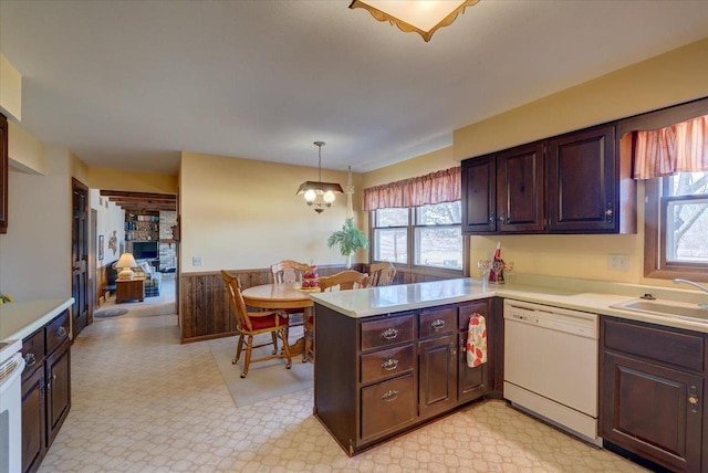 kitchen featuring dishwasher, light countertops, light floors, and a sink