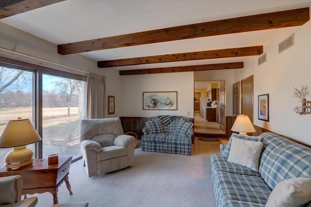 living area featuring beam ceiling, carpet flooring, and visible vents