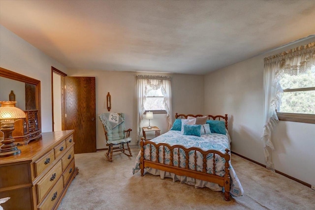 bedroom with baseboards and light carpet