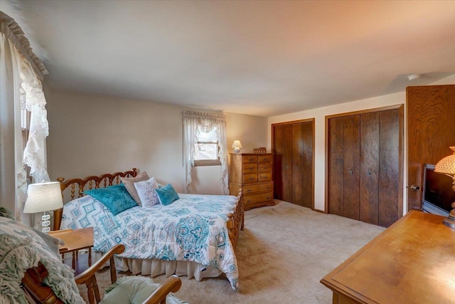 bedroom with carpet and multiple closets