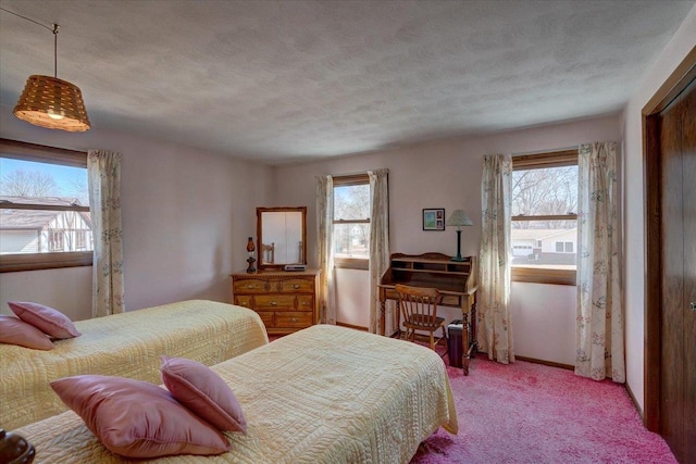 bedroom featuring multiple windows, a textured ceiling, and light carpet