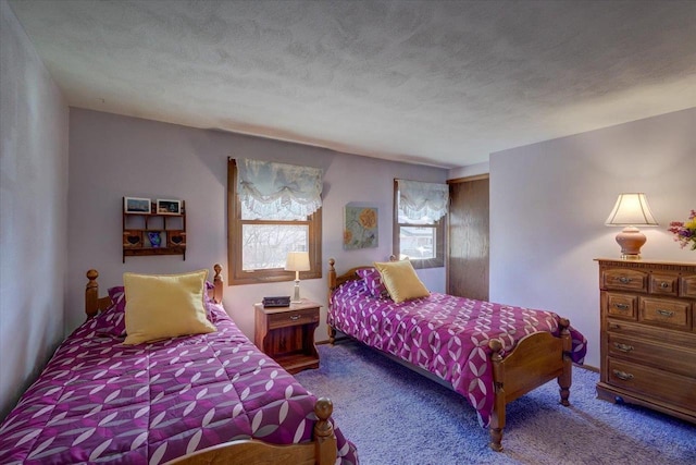 bedroom with a textured ceiling and carpet flooring