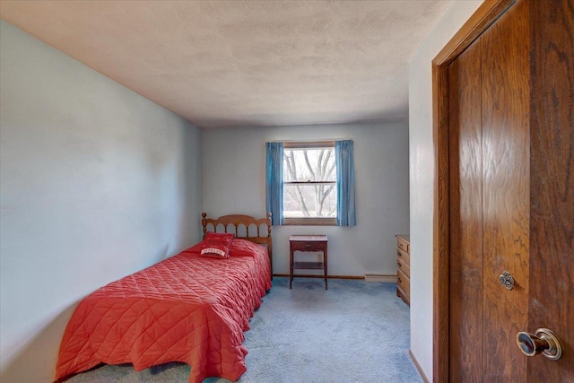 bedroom with baseboards, carpet floors, and a textured ceiling