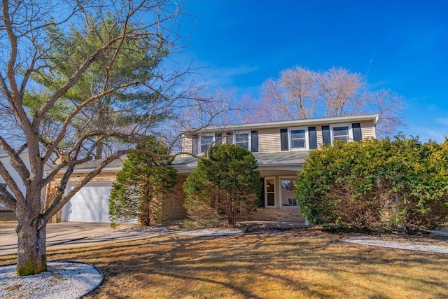 view of front of house featuring a garage, a front yard, brick siding, and driveway