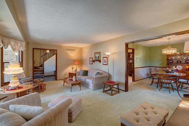 living area featuring visible vents, light colored carpet, stairs, and an inviting chandelier