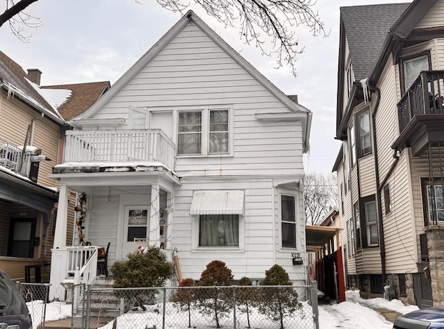 view of front of home with a fenced front yard and a balcony