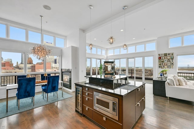 kitchen with wine cooler, open floor plan, stainless steel microwave, and dark wood finished floors