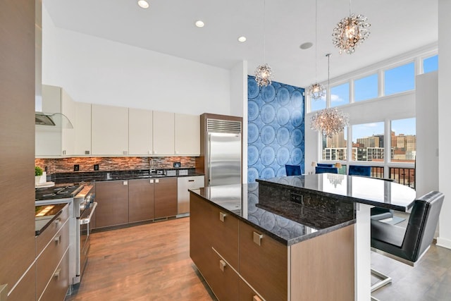 kitchen featuring an inviting chandelier, modern cabinets, a kitchen island, and high end appliances