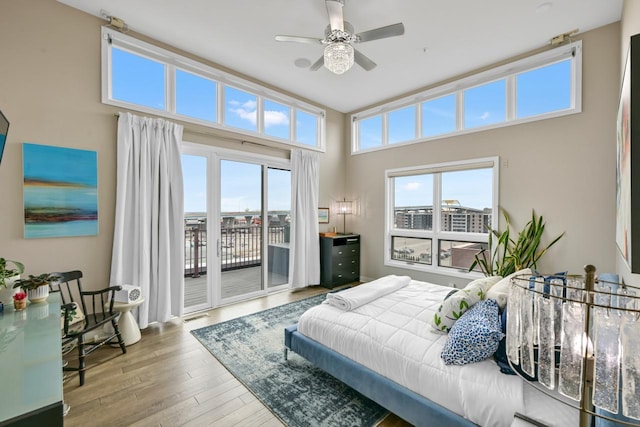 bedroom featuring hardwood / wood-style floors, multiple windows, visible vents, and access to exterior