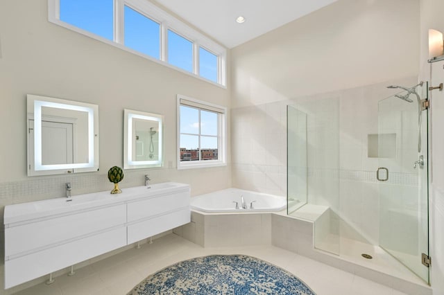 bathroom featuring a sink, a shower stall, a bath, tile patterned floors, and double vanity