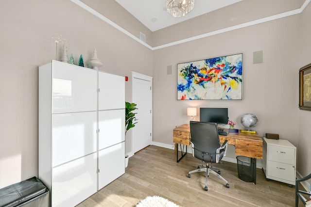 office area with light wood-style floors, visible vents, and baseboards