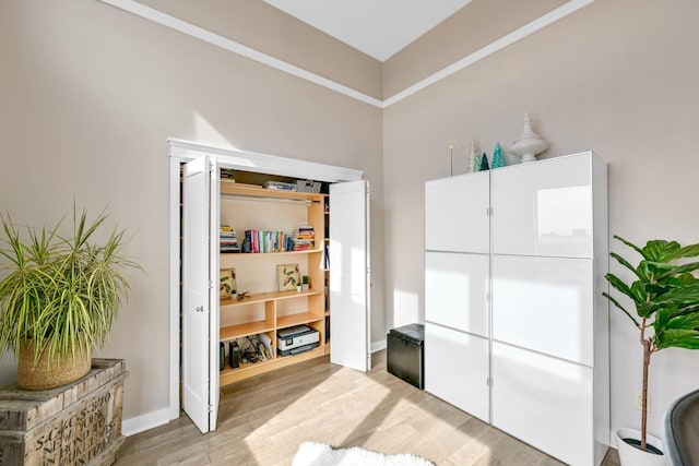 living area featuring light wood-style floors and baseboards