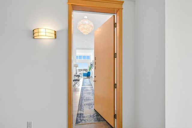 corridor with an inviting chandelier and wood finished floors