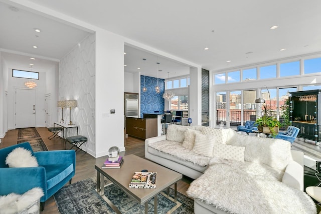 living room with an accent wall, baseboards, wood finished floors, and recessed lighting