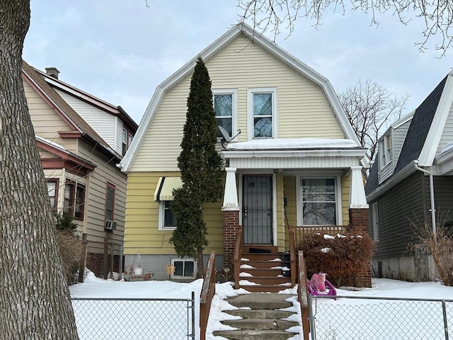 dutch colonial with brick siding, fence, and a gambrel roof