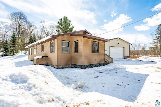 43240 County Highway D, Cable, WI 54821 - view of snowy exterior featuring a garage and an outbuilding
