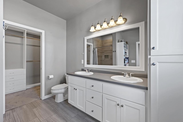 bathroom featuring a shower with curtain, a sink, toilet, and double vanity