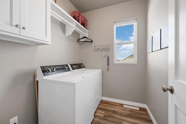 clothes washing area with cabinet space, independent washer and dryer, visible vents, and baseboards