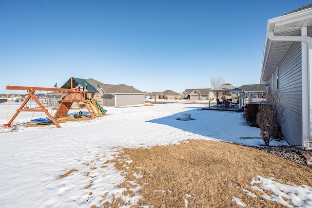 yard covered in snow featuring a residential view, playground community, and a gazebo