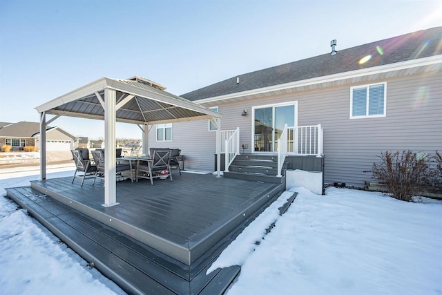 snow covered deck featuring outdoor dining area and a gazebo