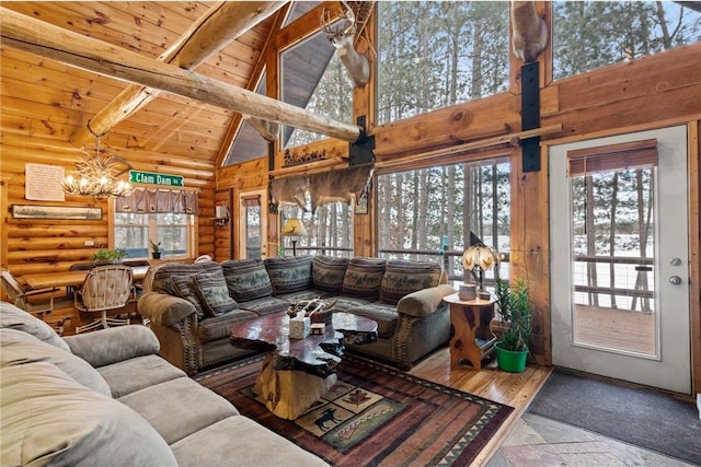 living room with high vaulted ceiling, rustic walls, wood ceiling, a chandelier, and beamed ceiling