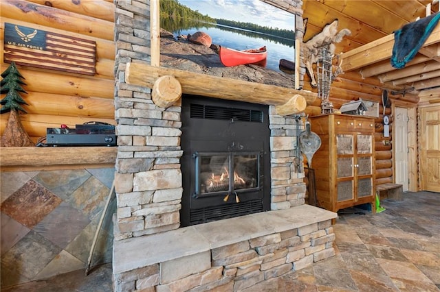 room details featuring an outdoor stone fireplace and rustic walls