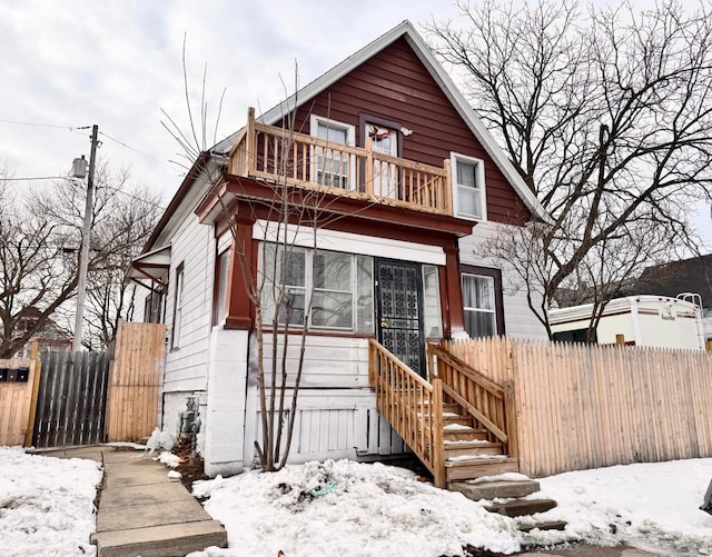 view of front of property featuring a balcony and fence