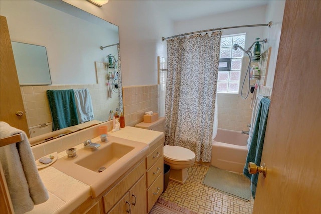 bathroom with tile patterned floors, toilet, tile walls, wainscoting, and shower / tub combo