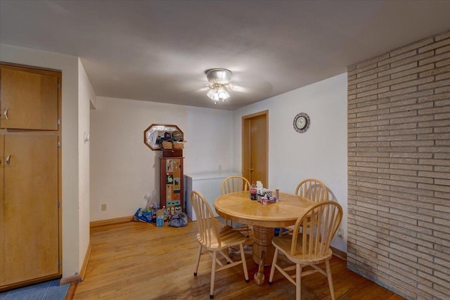 dining area with baseboards and light wood-type flooring