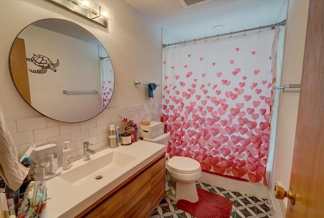 full bath featuring decorative backsplash, toilet, vanity, and shower / bath combo