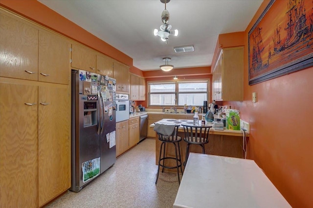 kitchen with a peninsula, light countertops, visible vents, and appliances with stainless steel finishes