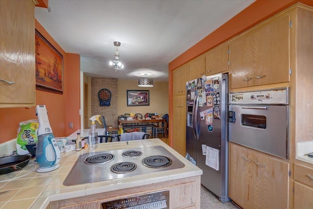 kitchen featuring tile countertops, a peninsula, and stainless steel appliances