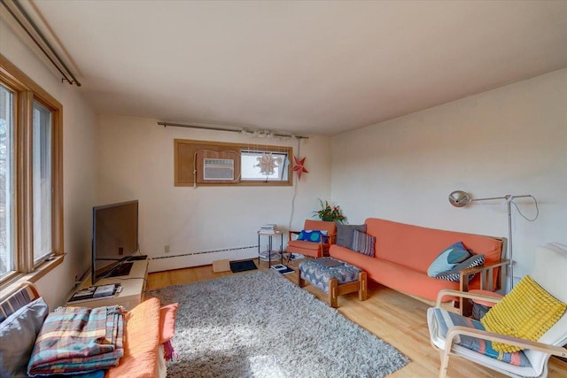 living area with a baseboard radiator, wood finished floors, and a wall mounted AC