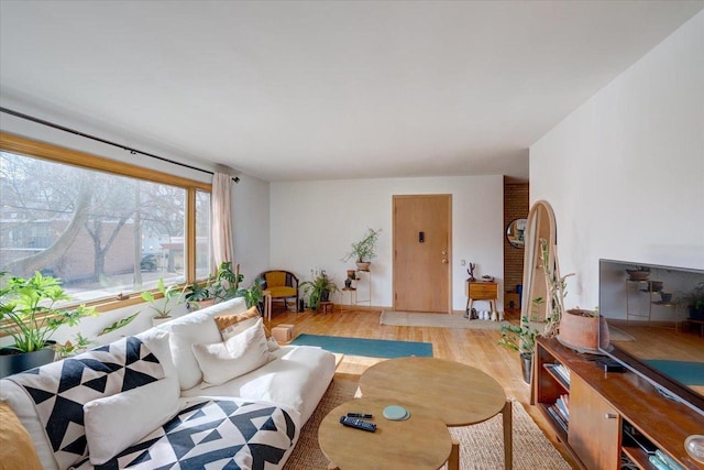 living area featuring arched walkways and light wood-style flooring