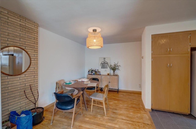 dining room with light wood-type flooring and baseboards