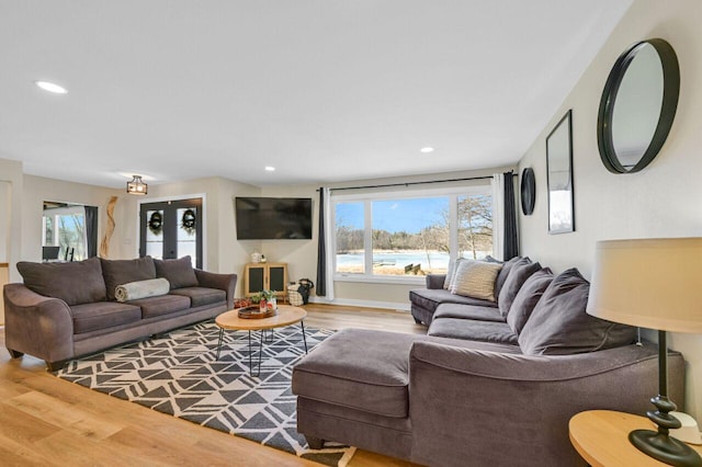 living area featuring recessed lighting, baseboards, plenty of natural light, and wood finished floors