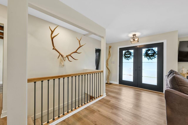 foyer with french doors, baseboards, and wood finished floors