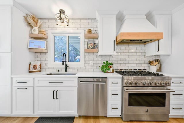 kitchen with a sink, open shelves, stainless steel appliances, light countertops, and custom exhaust hood