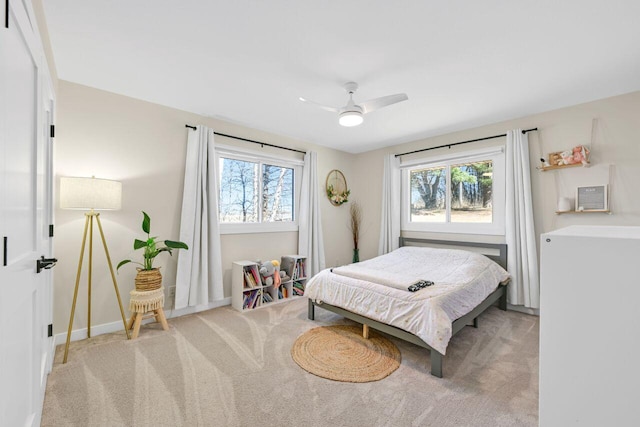 bedroom featuring baseboards, light colored carpet, and a ceiling fan