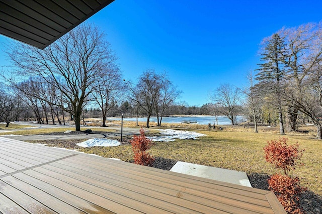 wooden deck with a lawn and a water view