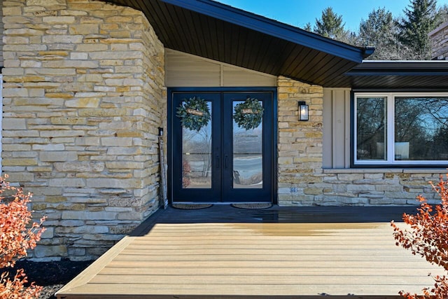 entrance to property featuring french doors and stone siding