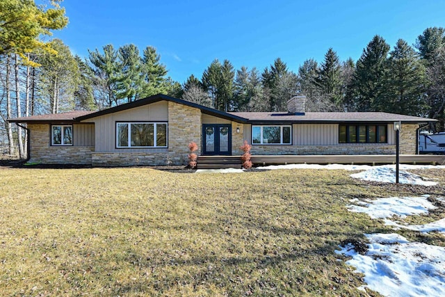 mid-century inspired home with stone siding, french doors, a chimney, and a front lawn