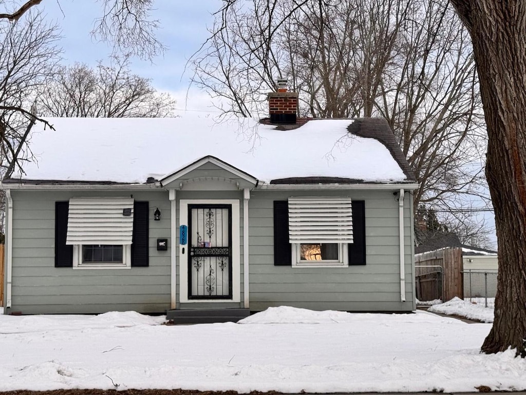 view of front of house featuring fence and a chimney