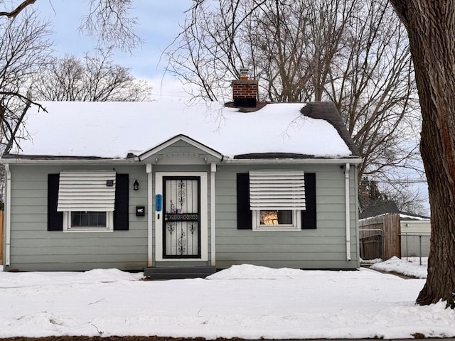 view of front of house featuring fence and a chimney