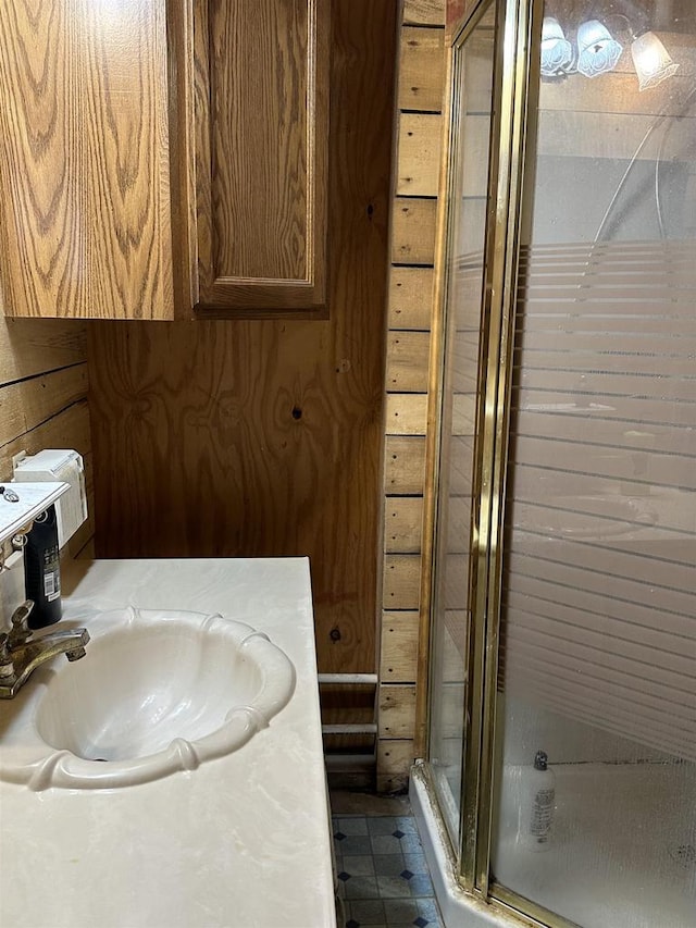 bathroom with a stall shower, tile patterned flooring, and vanity